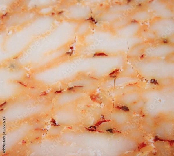 Fototapeta farmer's cheese crust of the cheese with the beans inside. texture as they Mature-hand-job. pieces of cheese on a cutting Board in different colors-orange marble Derby with paprika and tomato