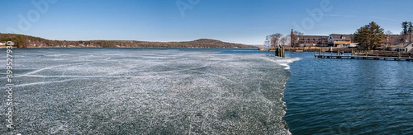 Fototapeta Panorama of Lake Winnipesaukee, Meredith, New Hampshire, as sheet ice melts on a a crisp sunny Spring morning.