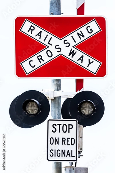 Fototapeta A close up vertical image of a railroad railway crossing sign post stop sign on a clean white background. See also same image but with lights on.