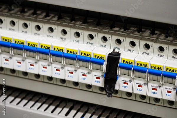 Fototapeta The circuit breaker is taped with black tape in a row with the others.