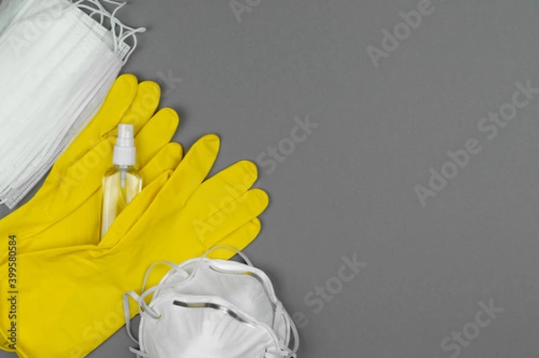 Obraz Masks, yellow gloves, respirators and antiseptic on a gray background.
