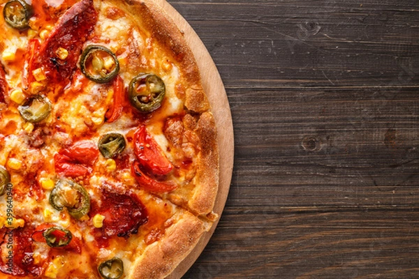 Fototapeta Fresh pizza with tomato sauce, black olives, mozzarella cheese, ham on wooden table closeup. Space for text or copy space. Pizza menu. Restaurant menu advertise