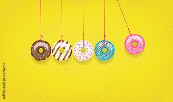 Fototapeta Newton's cradle from doughnuts. Collision balls made from donuts. Harm of sugar, donuts time or healthy diet concept. Dependence on flavoring, diabetes problems, weight loss.