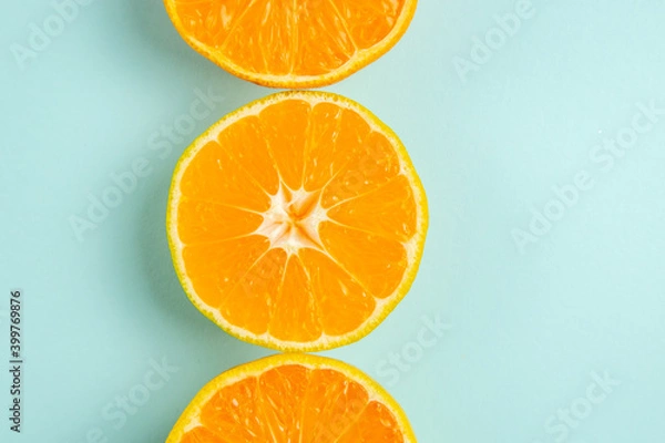 Fototapeta top view fresh tangerine slices lined on the light-blue background color orange photo juice fruit citrus