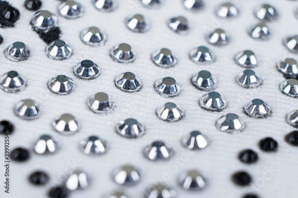 Fototapeta Macro shot white knitted fabric with many rhinestones pattern. Fashion cloth background texture