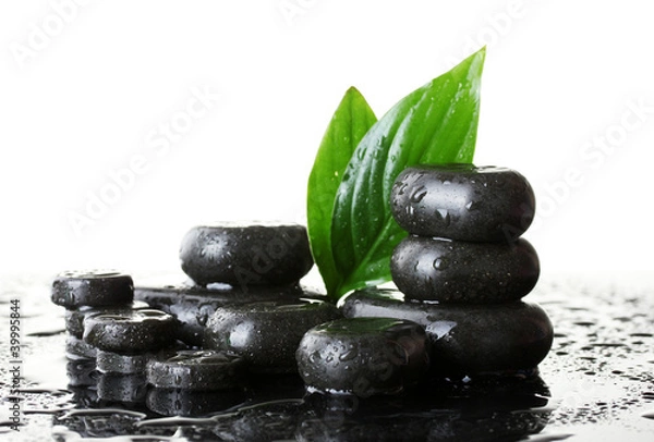 Fototapeta Spa stones with drops and green leaves on white background