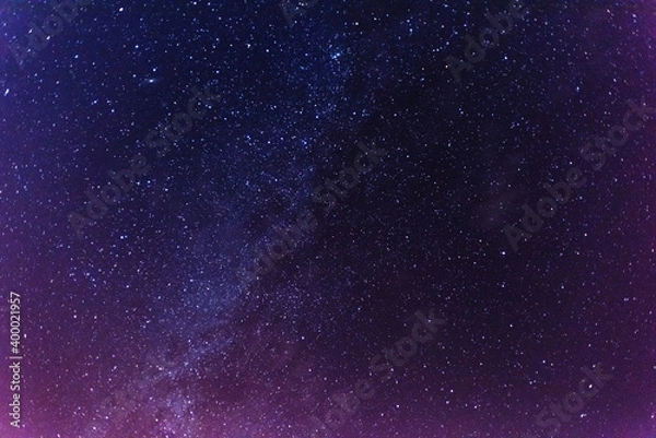 Fototapeta A magical starry night on the river bank with a large tree and a milky way in the sky and falling stars in the summer.	
