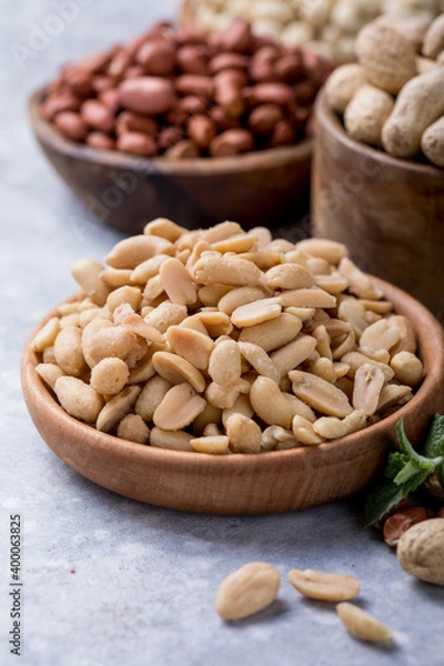 Obraz Roasted salted peanuts. Crispy nuts in bowl on stone table.