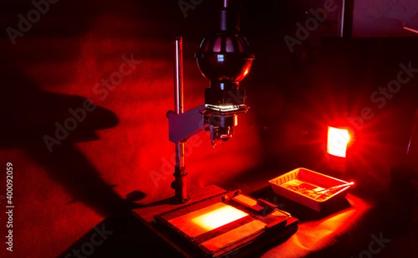 Fototapeta Analog photo printing. Photolaboratory. Red light
