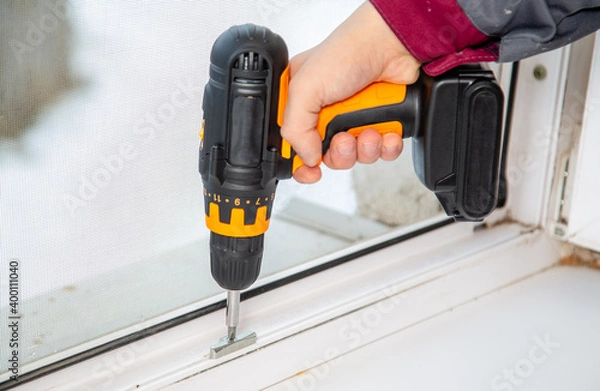 Obraz the master of plastic windows works with a cordless drill