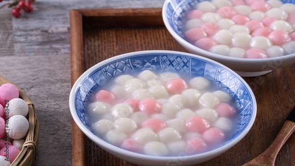 Fototapeta Close up of red and white tangyuan in blue bowl on wooden background for Winter solstice.