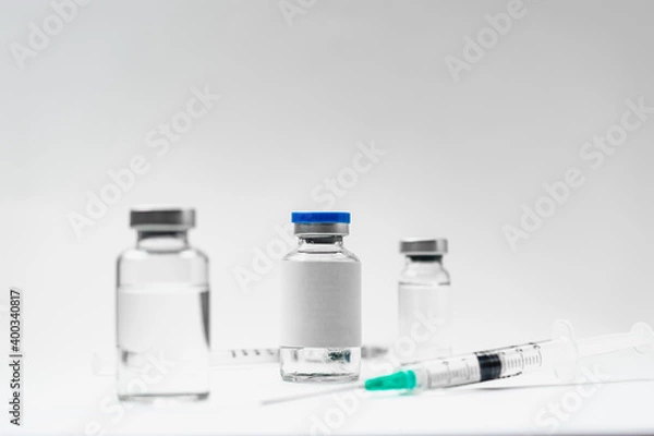 Fototapeta Medical treatment syringes and vaccine bottles in white environment 