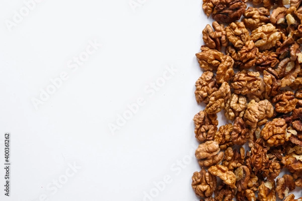 Fototapeta Top view of peeled walnuts placed on a white