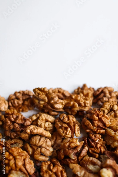 Fototapeta Top view of peeled walnuts placed on a white