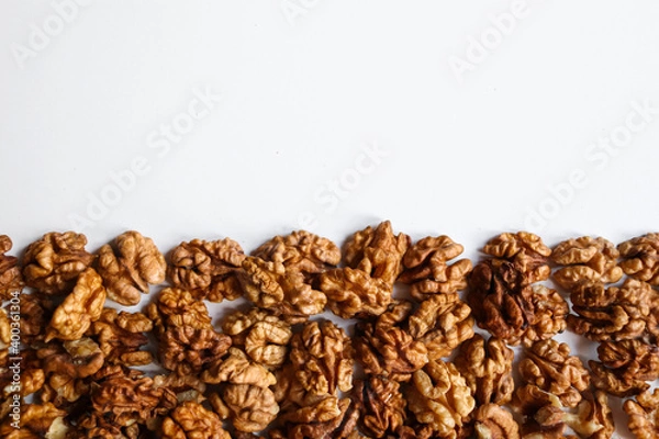 Fototapeta Top view of peeled walnuts placed on a white