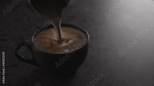 Fototapeta pour hot chocolate into black cup on concrete countertop with copy space under dim light