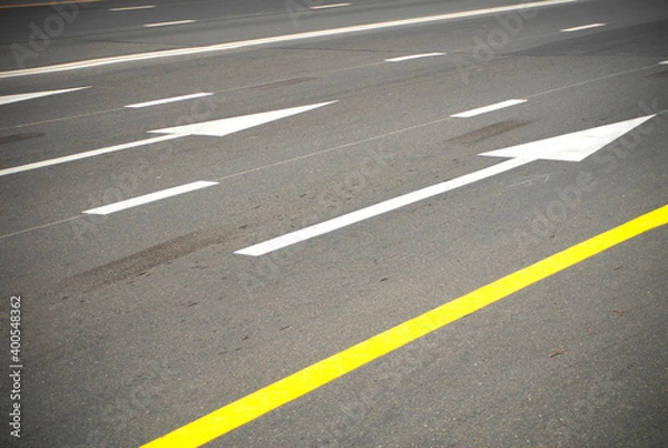 Fototapeta Direction arrows and lines on an asphalt road.