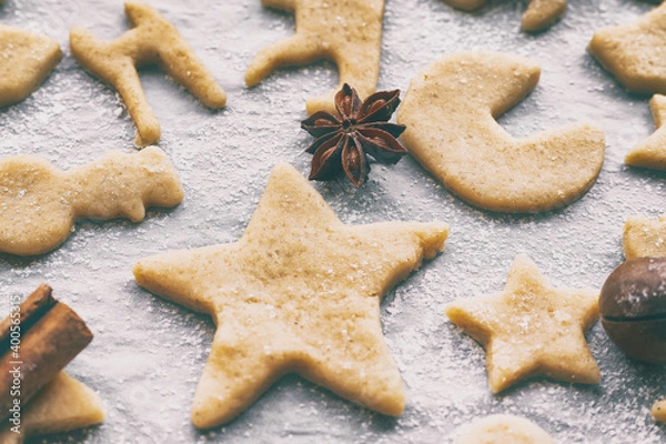 Fototapeta making homemade christmas or new year cookies of different shapes on parchment craft paper