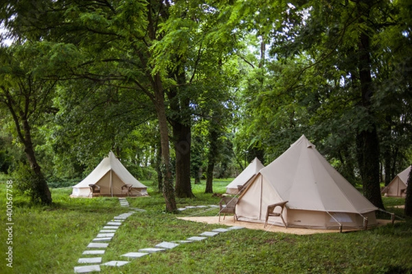 Fototapeta Glamping site in the woods on a calm afternoon.