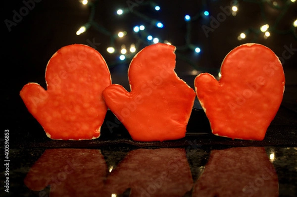 Obraz Three red mitten cookies.  One has a bite out of it.