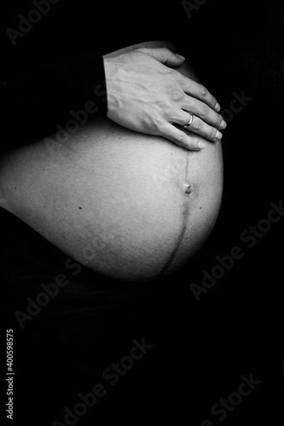 Obraz Close up photo shoot of pregnant bump with hands on it.