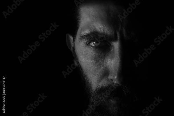 Obraz medio rostro con mirada directa en fondo negro oscuro
