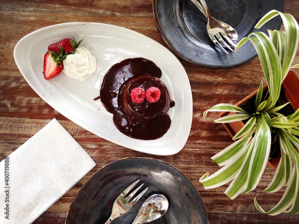 Fototapeta Top view of dessert, the chocolate lava cake, topped with raspberries and strawberries.