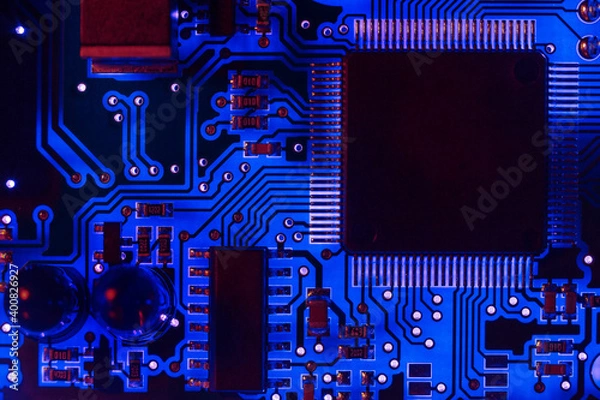 Fototapeta Close-up of a modern blue printed circuit board (PCB) with stripes of conductors between a transistor and an electronic equipment processor. IT technology repair in programming, upgrade and abstract 