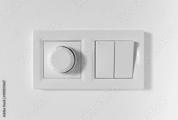 Fototapeta Pair of simple light switches with dimmer. Inexpensive plastic mechanical double switch with thermostat against white wall. Old air conditioner control panel. Smart Home Climate Control Appliances