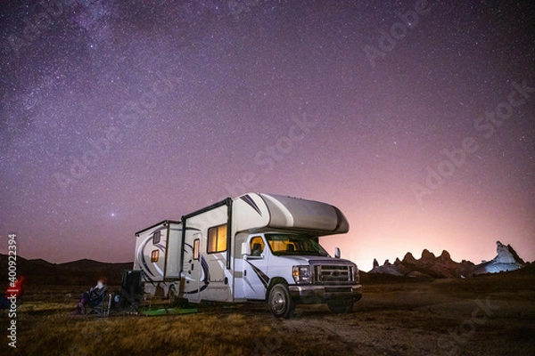 Fototapeta Campers gaze at Milky Way by their RV