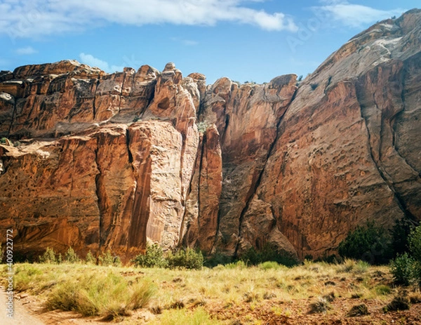 Fototapeta Unbelievable sandstone cliff and superlative domes with tumbleweeds on a hot summer partly cloudy day in Capitol Reef National Park in Southern Utah