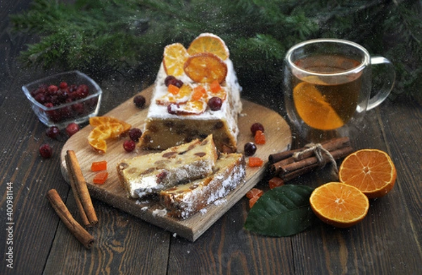 Fototapeta Homemade tangerine cupcake. Fir branches, spices and a cup of tea on a dark wooden table.