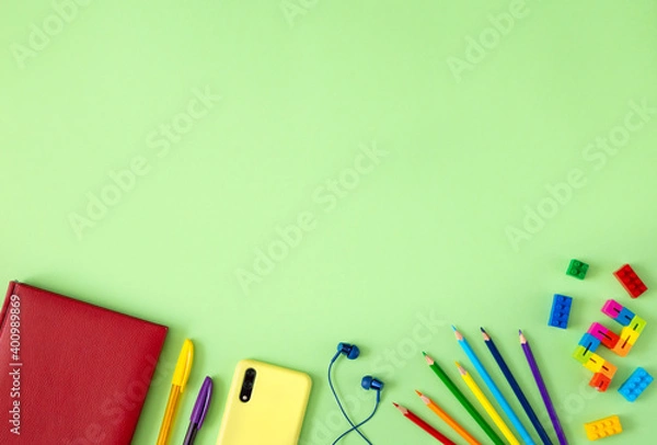 Fototapeta Modern childhood concept: smartphone, headphones, toys, pencils and notepad