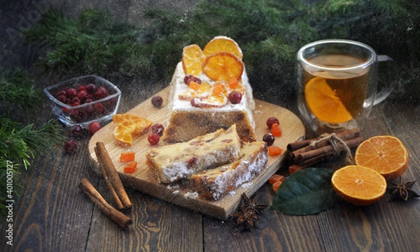 Fototapeta Homemade tangerine cupcake. Fir branches, spices and a cup of tea on a dark wooden table.