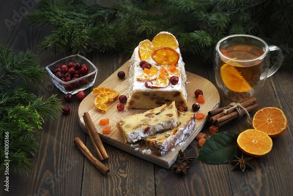 Fototapeta Homemade tangerine cupcake. Fir branches, spices and a cup of tea on a dark wooden table.