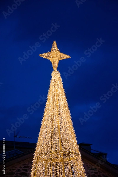 Fototapeta Vertical view of the illuminated Christmas tree and star of the decoration of Puebla de Sanabria