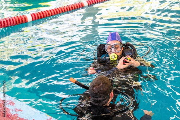 Fototapeta pair of divers in the water planning an activity