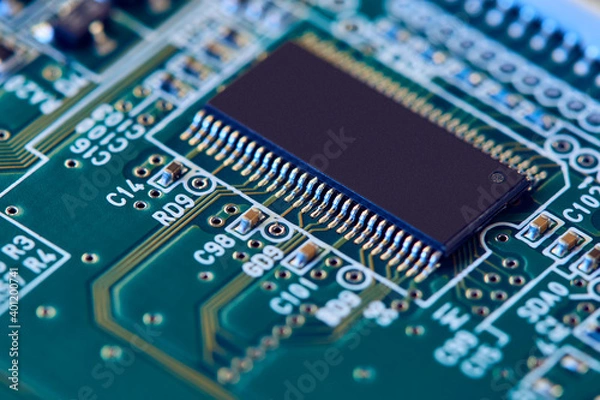 Fototapeta Electronic circuit board with electronic components such as chips close up. Blurry background.	