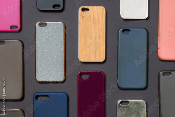 Fototapeta Pile of multicolored plastic back covers for mobile phone. Choice of smart phone protector accessories on black background. A lot of silicone phone backs or skins next to each other