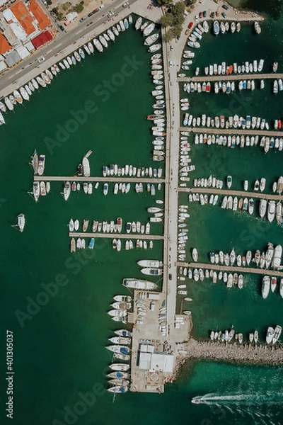 Fototapeta Aerial drone view of Marina on greek Aegina Island with many parking boats and yachts during sunlight.