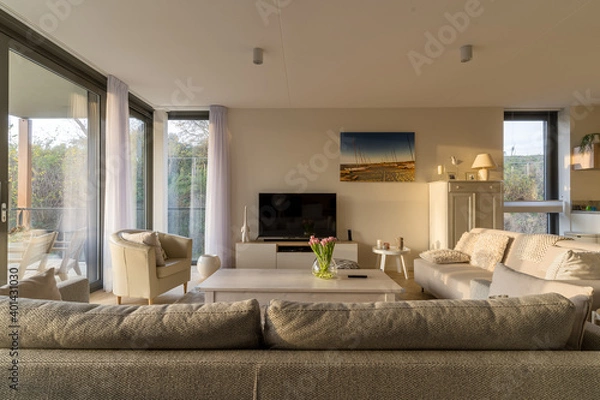 Fototapeta Modern living room with dune facing terrace view in the evening sun