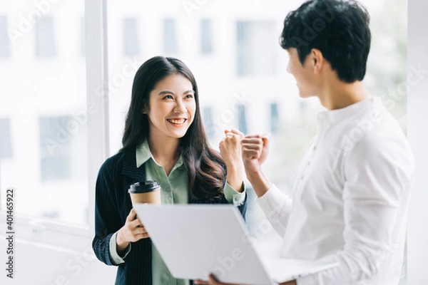 Fototapeta Two Asian colleagues rejoiced at the group's victory