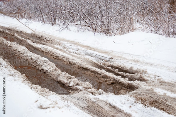 Fototapeta Puddles on a snowy road in early spring.