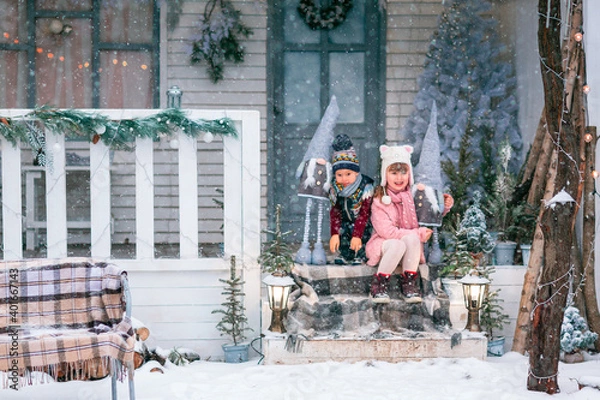 Obraz Happy little kids sitting on the porch of the Christmas decorated house outdoor