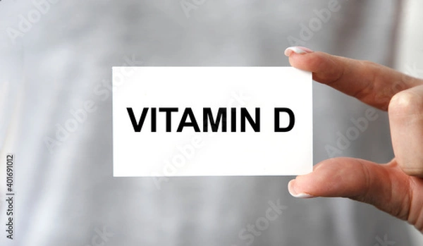 Obraz The girl holds a business card with the text vitamin D.