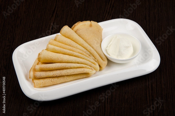 Obraz pancakes with sour cream in a white dish