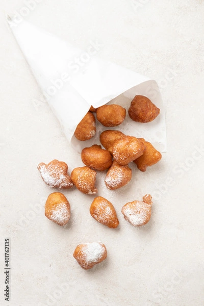 Fototapeta Fried beignets in a typically cornet paper, carnival food in low lands.
