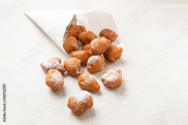 Fototapeta Fried beignets in a typically cornet paper, carnival food in low lands.