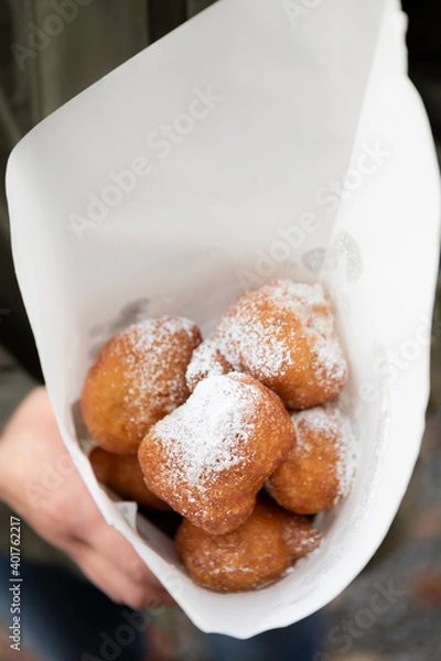 Fototapeta Fried beignets in a typically cornet paper, carnival food in low lands.