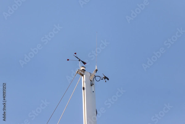 Obraz Top of the yacht's mast. Equipment on the top of the mast. Wind meter and weather indicator.